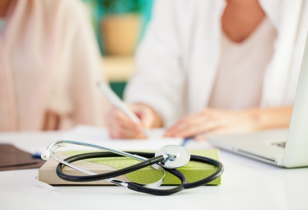 Female doctor writing a prescription to her patient.の写真素材