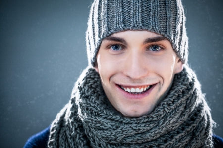 Handsome young man wearing a knit hat and a scarf.の写真素材