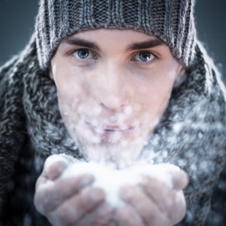 Handsome young man playing with snow.の写真素材