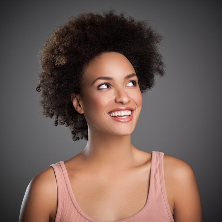 Portrait of a beautiful smiling African woman looking up.の写真素材