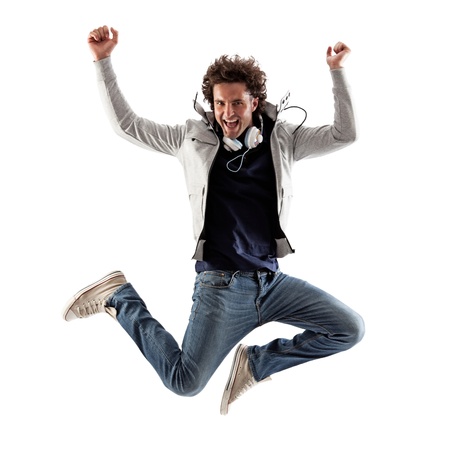Cool Caucasian man with headphones around his neck jumping.の写真素材
