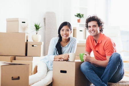 Young multi-ethnic couple having a break while moving into their new home.の写真素材