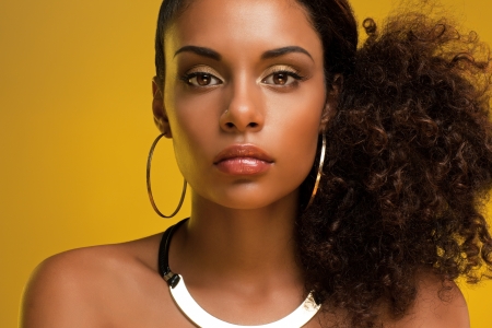 Portrait of a beautiful young African woman wearing gold jewelry.の写真素材