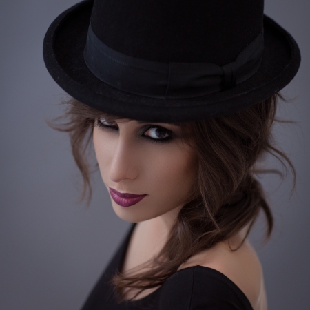 Beautiful young woman posing with a top hat on her head.の写真素材