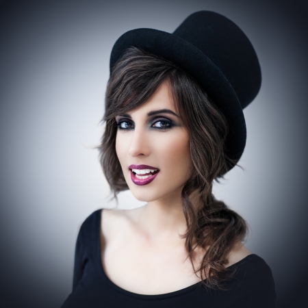 Portrait of a beautiful young elegant woman wearing a top hat.の写真素材