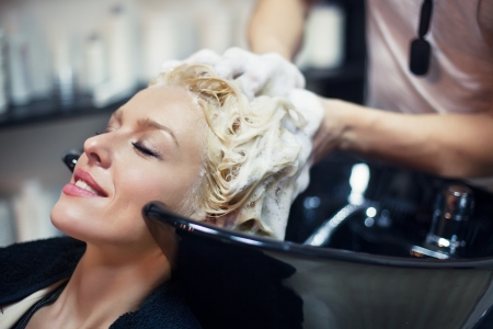 Smiling woman having her hair washed at the hairdresser's.の写真素材