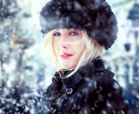 Beautiful mid-adult woman wearing a fur hat standing outdoors on a winter day.