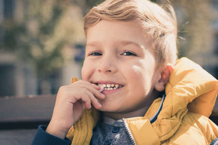Portrait of happy boy eating a candy and looking at camera.