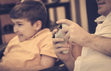 Close-up of father and son playing video games at home.の写真素材