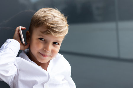 Smiling little by using smart phone and talking to someone. Copy space.の写真素材