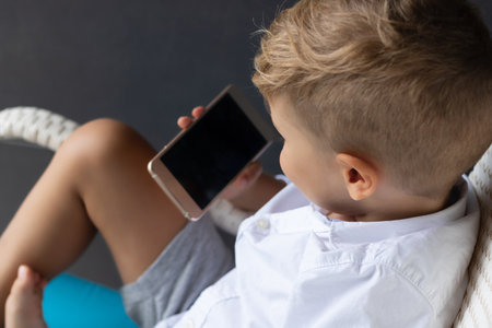 Close-up of boy having video call over mobile phone.の写真素材