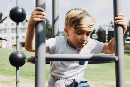 Small boy having fun while being on the playground at the park.の写真素材