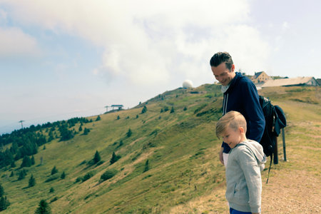 Happy boy and his father enjoying a day in nature of the mountains.の写真素材