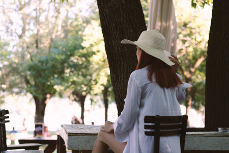 Rear view of a woman enjoying in summer day at beach bar.の写真素材