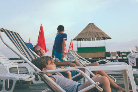 Relaxed family enjoying on a pier on summer vacation.の写真素材
