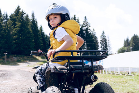 Cute kid on quadbike driving off road and looking at camera.の写真素材