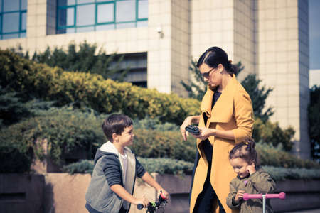 Mother and kids talking while spending day together in the city.の写真素材