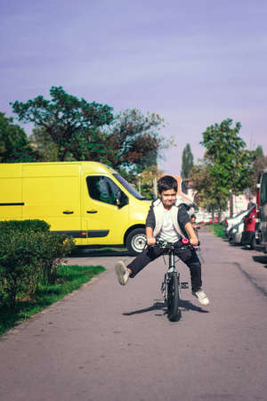 Little boy having fun on his bike while cycling on the street.の写真素材