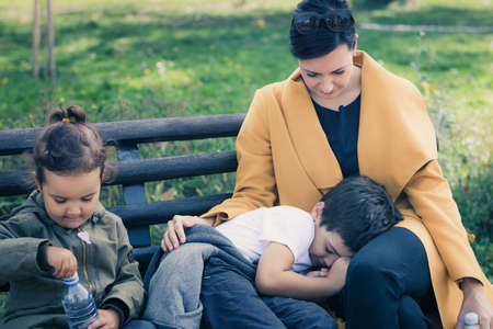 Caring mother comforting her son while spending a day with her kids in nature.の写真素材