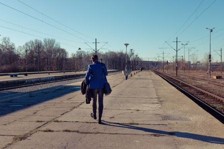 rear view of businessman walking at train station platform.