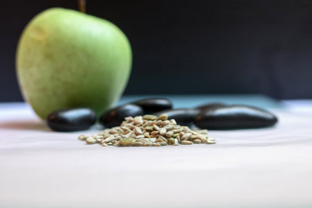 Healthy snack. Sunflower and pumpkin seeds with apple in background.の写真素材