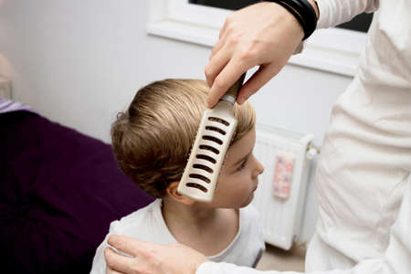 Unrecognizable father brushing son's hair in the morning.の写真素材