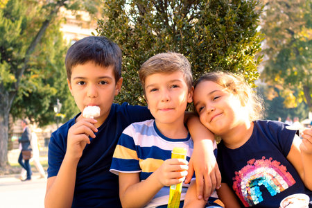 Small group of happy kids enjoying in ice cream outdoors.の写真素材