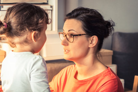 Middle aged mother enjoying in conversation with her small girl.の写真素材