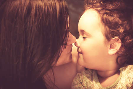 Loving mother and daughter touching noses while showing affection to each other.
