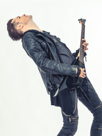 Hard rock guitarist enjoying while playing electric guitar on white background.の写真素材