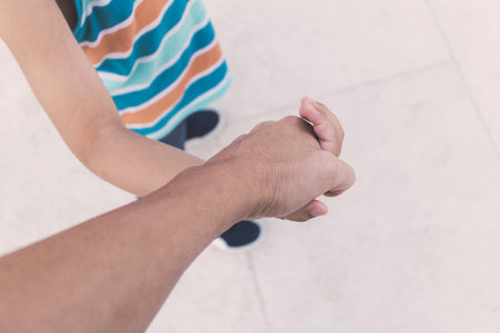 Close up of mother and son holding hands. Close up of child holding parent's hand.の写真素材