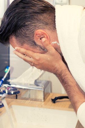 Close up of man washing face in the bathroom.の写真素材