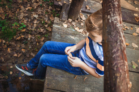 High angle view of kid relaxing on wooden bridge in nature.の写真素材