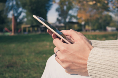 Close up of woman text messaging on mobile phone.