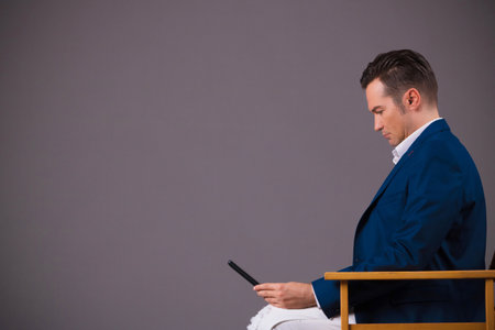 Side view of entrepreneur using digital tablet against gray background. Copy space.の写真素材