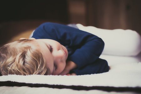Close-up of cute kid sleeping on the bed.の写真素材