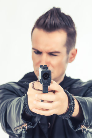 Close up of man aiming with handgun on white background.の写真素材