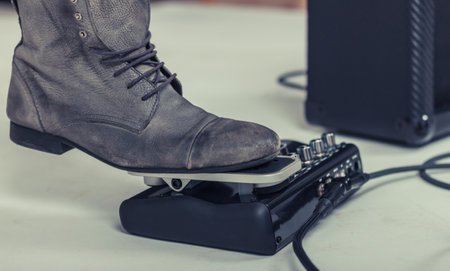 Close up of guitar player using guitar processor and pressing wah-wah pedal.の写真素材