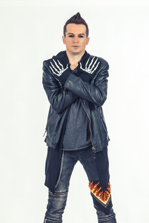 Rebellious musician standing with crossed arms while wearing skeleton gloves.の写真素材