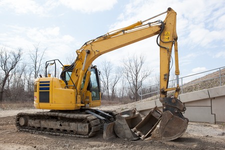 A yellow backhoe parked at a construction site