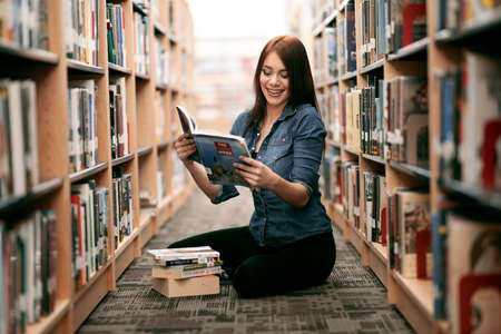Young Woman Reading a Book at Local Library