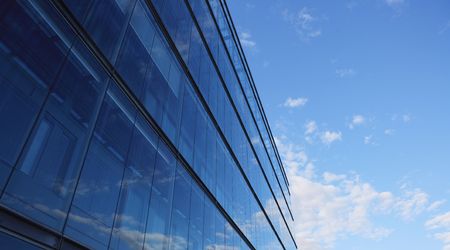 Glass wall of an office building, reflections of clouds