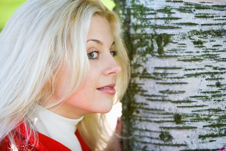 Portrait of young woman leaning to treeの写真素材