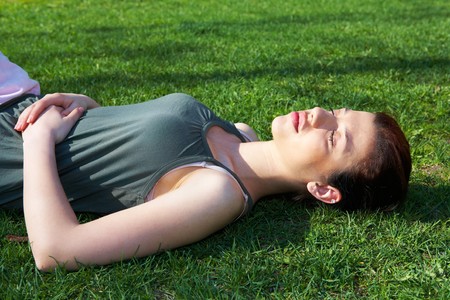 Teenage girl resting in park eyes closedの写真素材