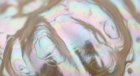 Close-up of an iridescent, pearlescent surface with wavy, organic patterns and soft, shimmering pastel colors, creating an abstract texture background.の素材