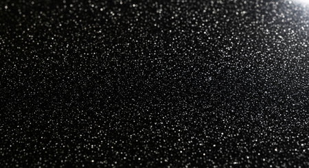 Close-up of sparkling white glitter on a dark background, creating a festive and abstract texture. Ideal for backgrounds, celebrations, and design elements.の素材