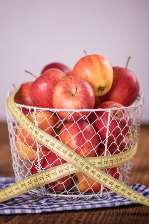 red apples with tape measure healthy diet weight loss conceptの写真素材