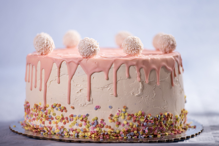 detail close up of coconut balls on top of a pink cakeの写真素材