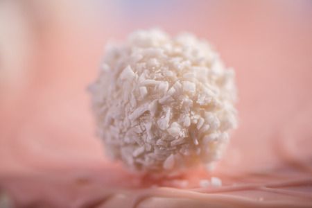 detail close up of coconut balls on top of a pink cakeの写真素材