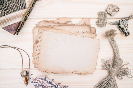 Vintage style rustical mockup with an old blank paper on a wooden texture, amulets and pebbles. Copy space. Place for textの写真素材
